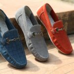Three colorful leather loafers displayed outdoors showcasing style and elegance.